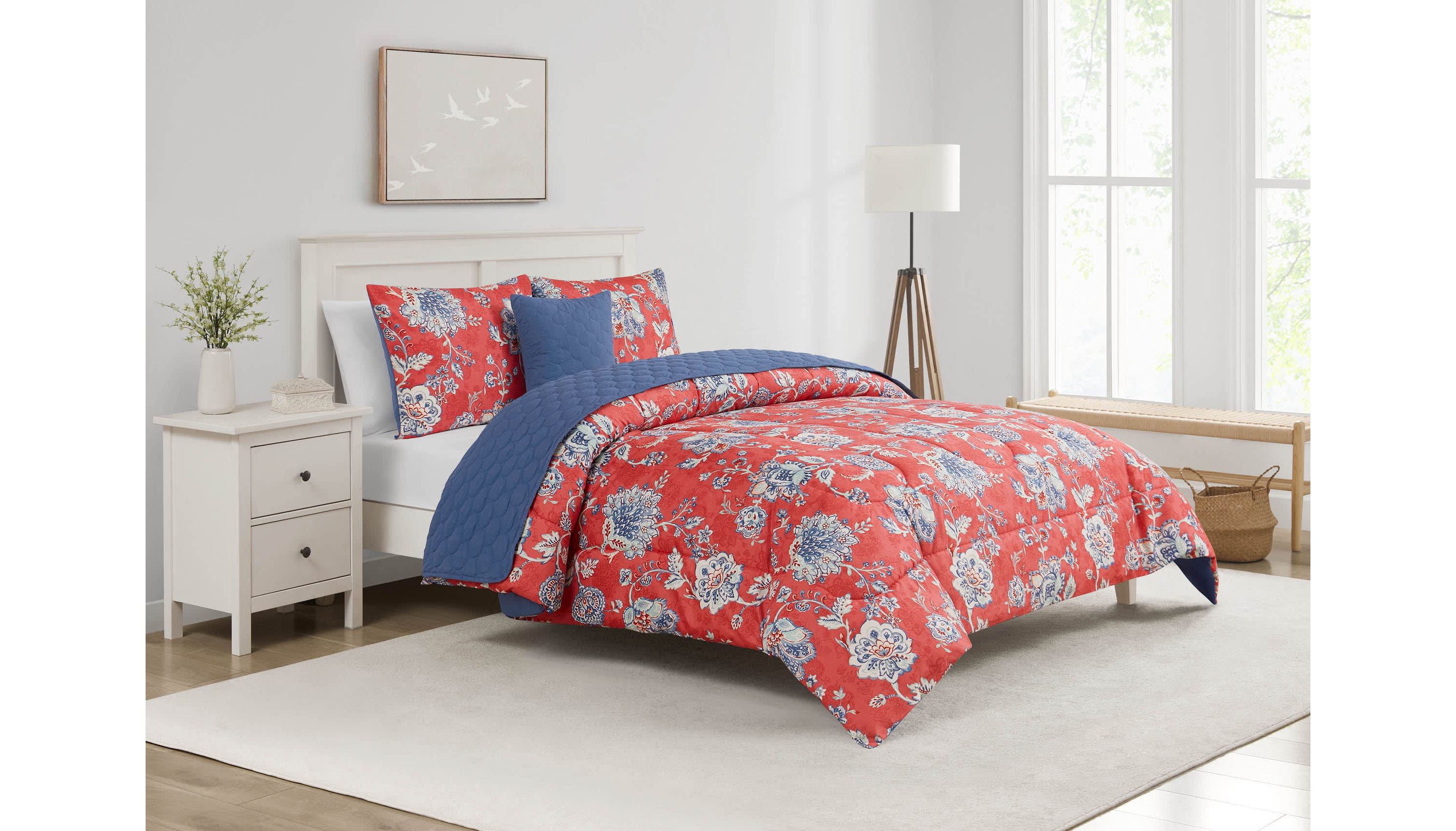 Brighten your bedroom with the Zinnia Blue 5pc Comforter and Quilt Set. Featuring a vibrant red floral print with a reversible blue quilt, this set includes a comforter, quilt, 2 shams, and a decorative pillow—perfect for bold style and cozy, layered comfort year-round.